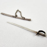 Gabriel Riddle london (C1830-1840) silver miniature sword in silver scabbard. This silver sword with its silver scabbard both have the makers name stamped on to them. G.Riddle London. The scabbard has it to the side and the sword is marked on the hilt or hand guard. Two minor dents and one small dent in the scabbard that does not effect the sword drawing out of it. Other than damage explained product in overall good condition  Measures: Height 6.1cm, Width 1cm, Depth 0.4cm.