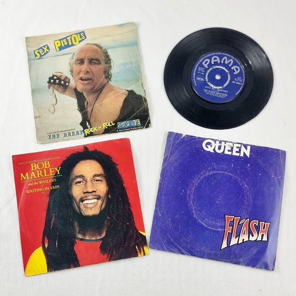 Four Vintage Single Records Queen, Bob Marley, Sex Pistols, and The Other Brothers.
