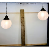 Pair of vintage industrial lights with Cast iron light fixing and a perspex ball shape shade. These have a great industrial look and style to them showing signs of wear with Scuffs and scraps to the shade of each light shade. Both lights in working order and look great hung up and lit up.   Measures: Height 60cm, Diameter approximately 36cm. Showing lights working