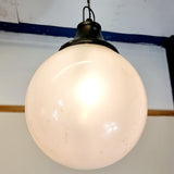 Pair of vintage industrial lights with Cast iron light fixing and a perspex ball shape shade. These have a great industrial look and style to them showing signs of wear with Scuffs and scraps to the shade of each light shade. Both lights in working order and look great hung up and lit up.   Measures: Height 60cm, Diameter approximately 36cm.