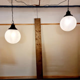 Pair of vintage industrial lights with Cast iron light fixing and a perspex ball shape shade. These have a great industrial look and style to them showing signs of wear with Scuffs and scraps to the shade of each light shade. Both lights in working order and look great hung up and lit up.   Measures: Height 60cm, Diameter approximately 36cm. Showing lights working