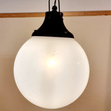 Pair of vintage industrial lights with Cast iron light fixing and a perspex ball shape shade. These have a great industrial look and style to them showing signs of wear with Scuffs and scraps to the shade of each light shade. Both lights in working order and look great hung up and lit up.   Measures: Height 60cm, Diameter approximately 36cm. Showing light working