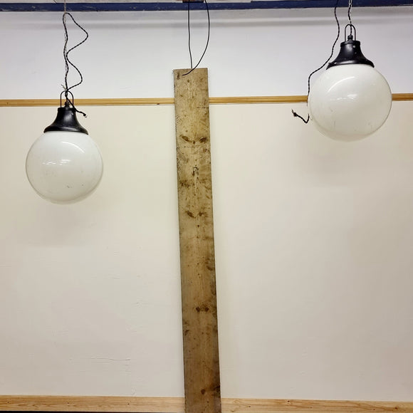 Pair of vintage industrial lights with Cast iron light fixing and a perspex ball shape shade. These have a great industrial look and style to them showing signs of wear with Scuffs and scraps to the shade of each light shade. Both lights in working order and look great hung up and lit up.   Measures: Height 60cm, Diameter approximately 36cm.