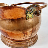 19th century Victorian copper coal scuttle. This coal scuttle features brass mounts to the side the are attached to a hinged copper handle and a single brass handle at the back of the scuttle. The coal scuttle has its normal signs of wear from being used for about 150 years as a coal scuttle should for its age, from denting of the copper from being used. Showing Close up some marks and discolouring due to age