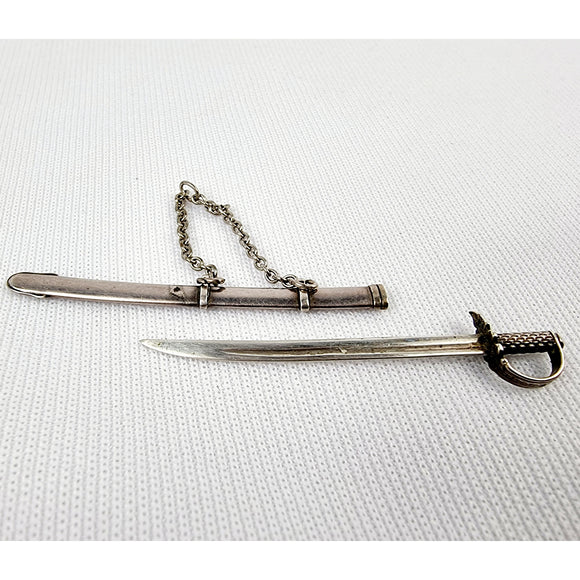 Gabriel Riddle london (C1830-1840) silver miniature sword in silver scabbard. This silver sword with its silver scabbard both have the makers name stamped on to them. G.Riddle London. The scabbard has it to the side and the sword is marked on the hilt or hand guard. Two minor dents and one small dent in the scabbard that does not effect the sword drawing out of it.  Measures: Height 6.1cm, Width 1cm, Depth 0.4cm.