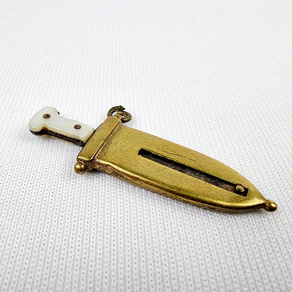 Brass and mother of pearl novelty cigar cutter in the form of a dagger. Marked M.S. This is a charming a antique cigar cutter that would make a great addition for a collector or for just having one of those one of pieces. The mother of pearl is cracked on one side of the handle bit is still securely on with no movement.   Measures: Height 5.3cm, Width 2cm, Depth 0.5cm.